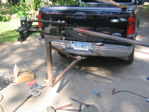 1978 Ford Bronco - A shop-built steel tubing bender or fabrication jig set up on a driveway behind a black Ford pickup with a Connecticut plate reading ICJ-00…