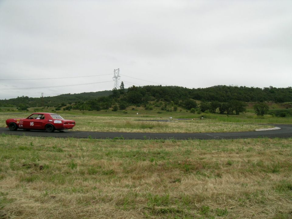 Red race car with number 16 on door driving on a track