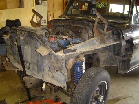 1979 Ford Bronco - A black late-1970s Ford Bronco Custom sits stripped in a wood-walled shop with both front fenders, hood and grille removed, leaving the rad…