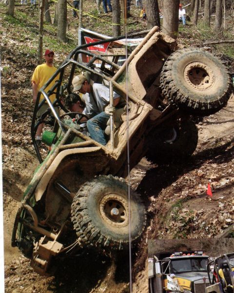 1992 Ford Bronco - Off-road buggy with roll cage climbing a steep dirt hill during an event.