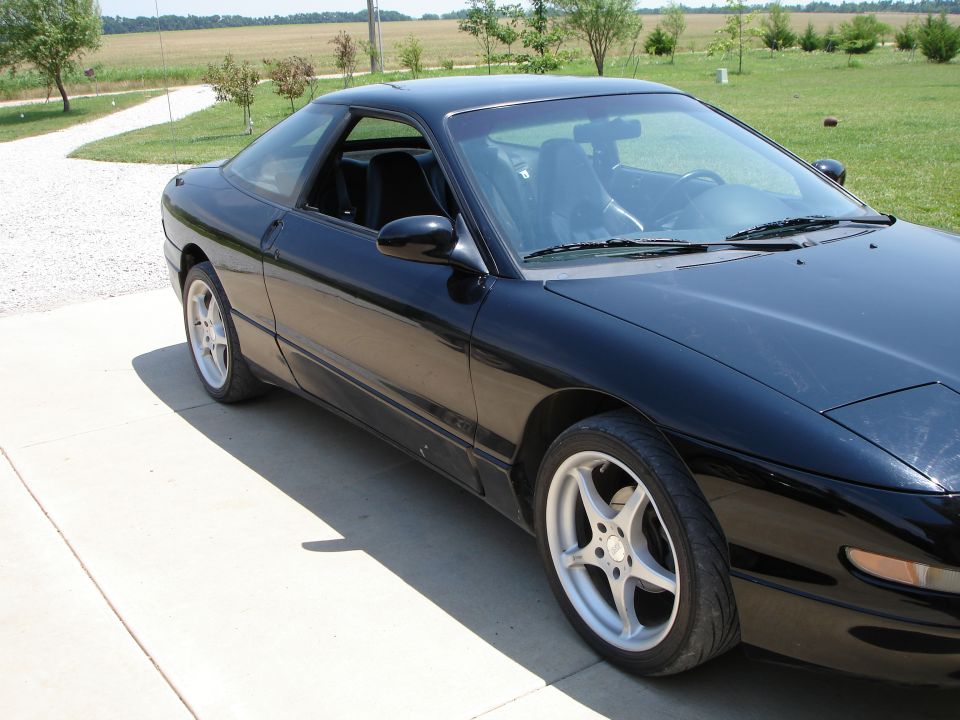 Black 1997 Ford Probe coupe parked on a concrete driveway