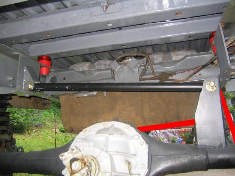 1978 Ford Bronco - Underbody shot of a freshly gray-painted frame and floor pan showing a rear axle housing with a white-painted differential, a black transve…