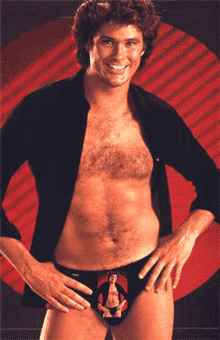 1990 Ford Bronco - A man poses in a black jacket and briefs with a red background.