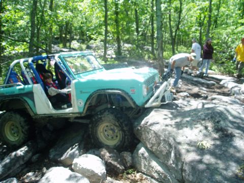1969 Ford Bronco - Ford Bronco tackling a difficult off-road course in a wooded area.