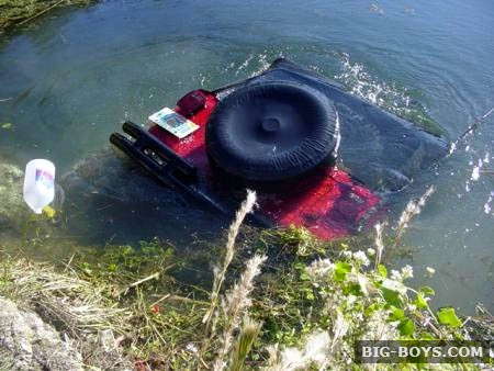 1995 Ford Bronco - A Ford Bronco is partially submerged in a body of water, with its rear end visible above the surface.