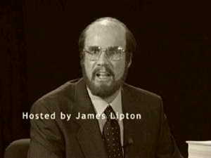 2002 Ford Taurus - A low-resolution sepia-toned television screengrab of a bearded person in glasses, a suit and tie speaking against a dark backdrop, caption…