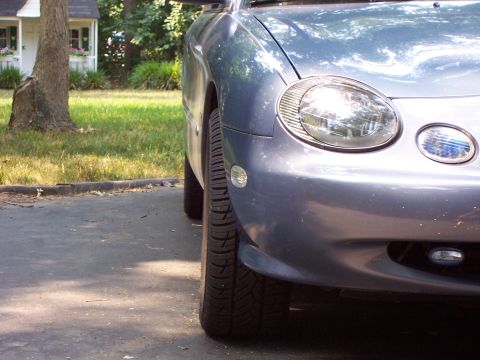 1999 Ford Taurus - A blue car's front corner is visible, with a watermark indicating the website Supermotors.net.