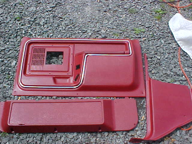 Red interior door panels and trim pieces on gravel