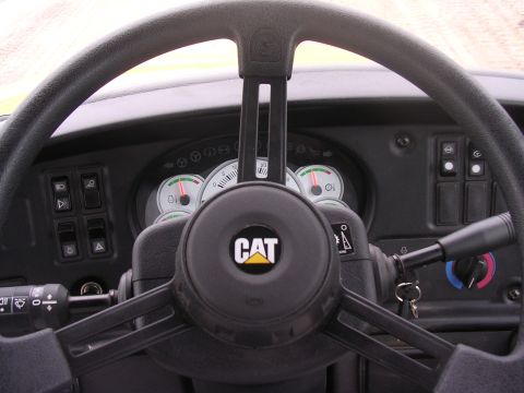 1985 Ford Bronco - The interior of a CAT vehicle shows the steering wheel, dashboard, and various controls.