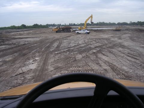 1985 Ford Bronco - Heavy machinery operates at a construction site under an overcast sky.