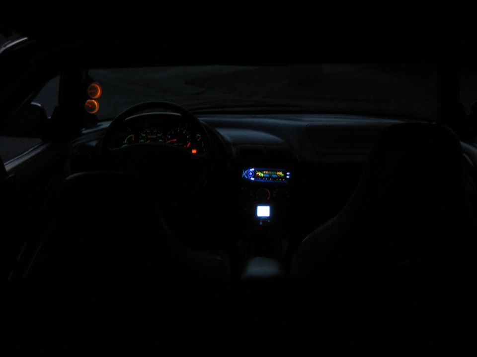 Car interior at night with illuminated dashboard and radio