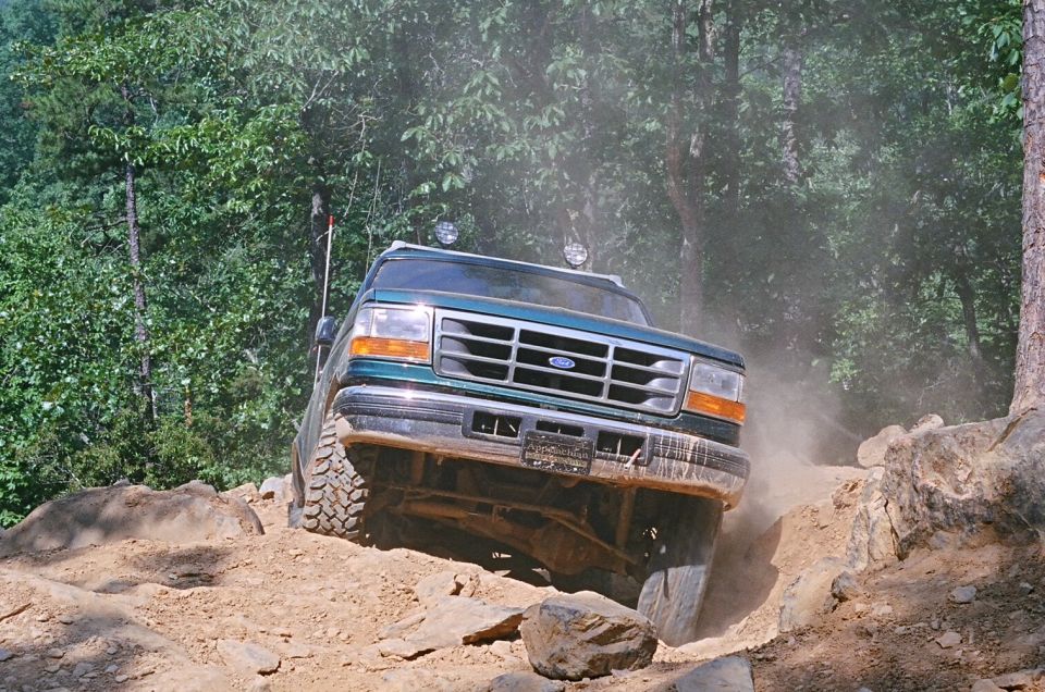Green SUV navigating rocky terrain