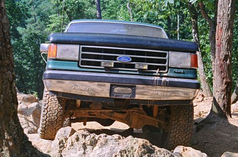 1990 Ford Bronco - 1990 Ford Bronco navigating a rocky off-road trail.