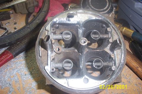 1979 Ford F-150 - A carburetor sits on a workbench covered in metal shavings, with tools visible in the background.