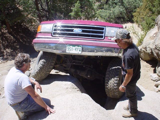 Red 1991 Ford Bronco front view on rocky trail