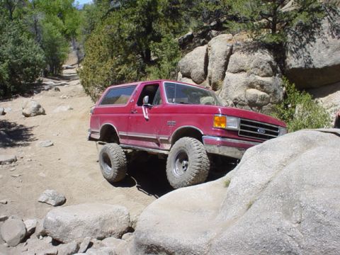 1991 Ford Bronco - This 1991 Ford Bronco navigates a rocky off-road path with large tires.