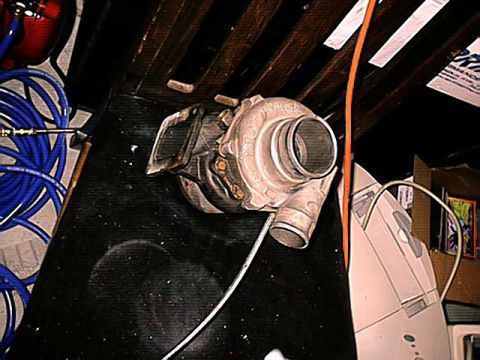 1994 Ford Probe - A turbocharger is shown with associated hoses and wiring, suggesting it is a vehicle part.