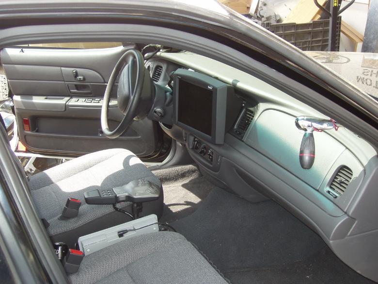 Crown Victoria police interior with dash-mounted computer screen and spotlight handle