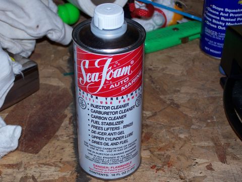 1986 Ford Bronco - A can of Sea Foam motor treatment is shown on a workbench, surrounded by various tools and cleaning supplies.