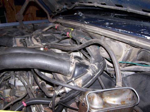 1986 Ford Bronco - Close-up view of a vehicle's engine bay, showing various hoses and electrical wiring.