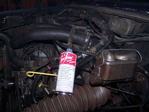 1986 Ford Bronco - Engine bay detail a can of Sea Foam fuel additive and a rusty brake fluid reservoir.