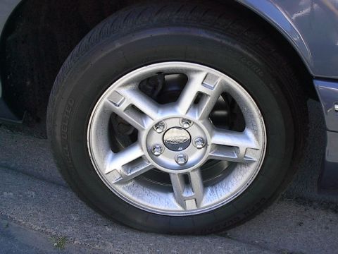 1985 Mercury Grand Marquis - Close-up of a car's wheel and tire assembly, showing the rim and tire tread.