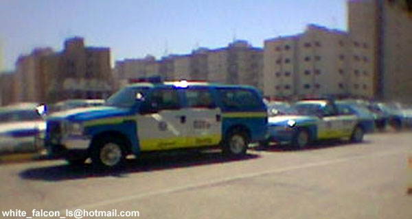 White and blue police SUV parked beside a marked sedan patrol car