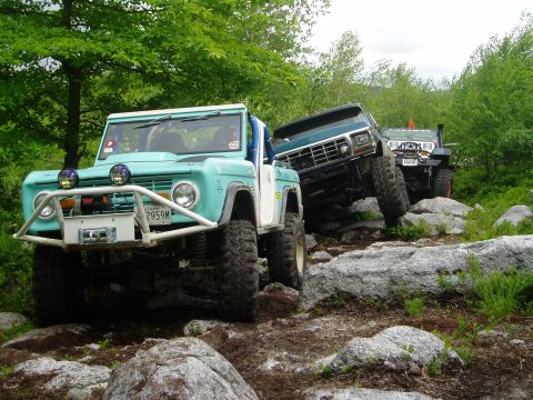 1969 Ford Bronco - Multiple off-road vehicles tackle a challenging rocky terrain during an outing.