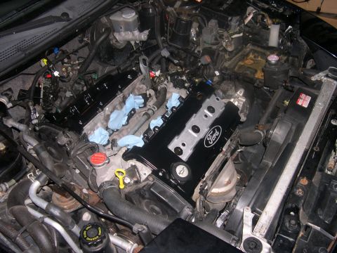1997 Ford Probe - The engine bay of a Ford vehicle, showing the engine block and various components during maintenance.