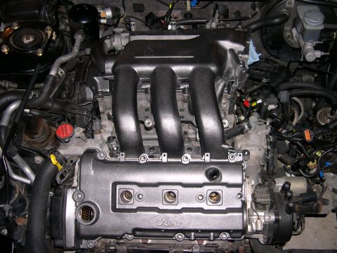 1997 Ford Probe - Close-up view of a car engine, showing the intake manifold and valve cover.