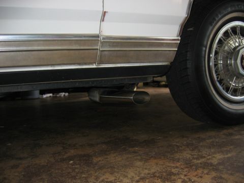 1985 Ford LTD Crown Victoria - Side view of a white 1985 Ford Crown Victoria LTD, focusing on the chrome trim and exhaust pipe.
