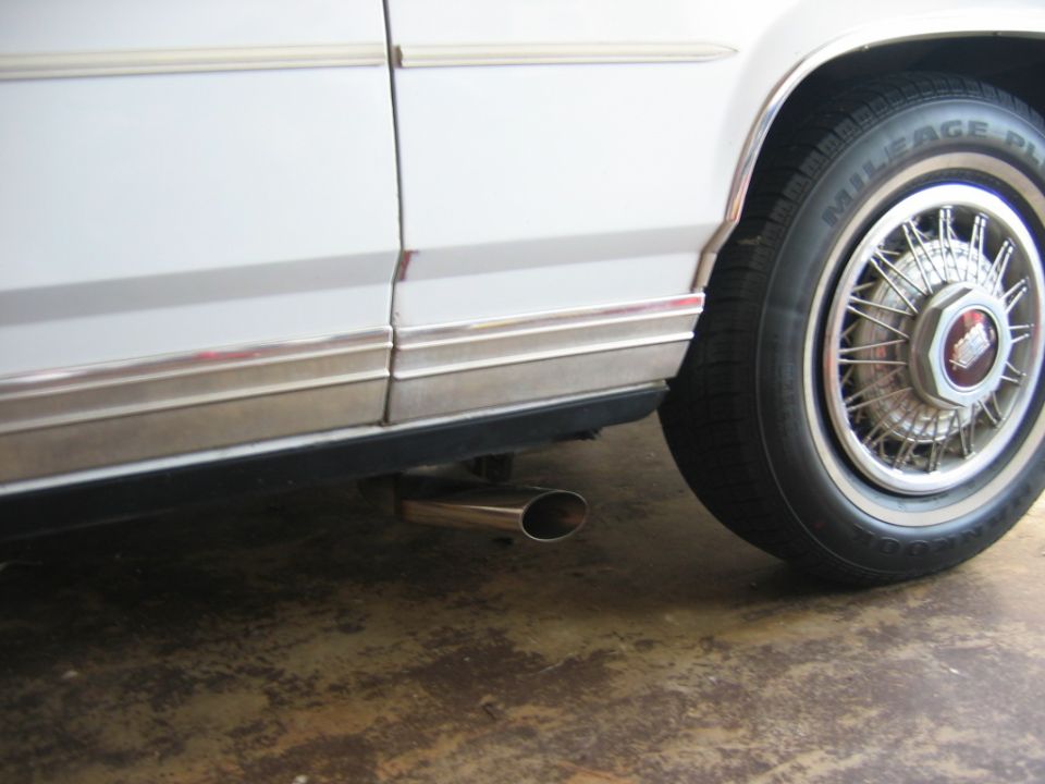 Chrome exhaust pipe on white car