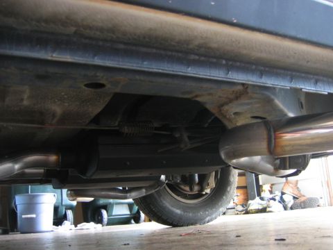 1985 Ford LTD Crown Victoria - The undercarriage of a vehicle, focusing on the exhaust system and frame components.