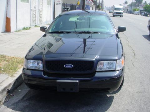 2003 Ford Crown Victoria - A black 2003 Ford Crown Victoria is parked on the side of a street, facing the camera.