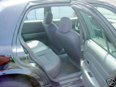 2003 Ford Crown Victoria - The interior of a 2003 Ford Crown Victoria is visible with the doors open, showing the front and rear seating areas.