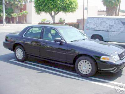 2003 Ford Crown Victoria - This black 2003 Ford Crown Victoria sedan is shown from a 3/4 front angle in a parking lot.