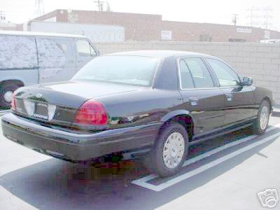 2003 Ford Crown Victoria - Rear view of a black 2003 Ford Crown Victoria sedan parked in a lot.