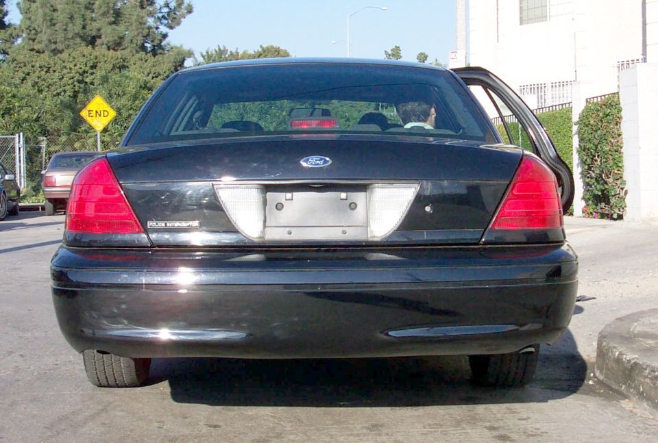 Rear view of a black 2003 Ford Crown Victoria with its driver's side door open