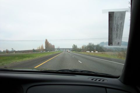 2003 Ford Crown Victoria - Driving on a highway with other vehicles and a sticker on the windshield.