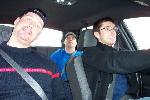 2003 Ford Crown Victoria - Three men are inside a vehicle, with two in the back seat and one driving.