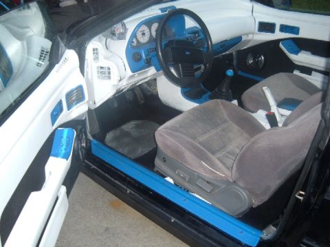 1989 Ford Probe - The interior of this car features custom white and blue upholstery and trim, with a prominent dashboard and seats visible.