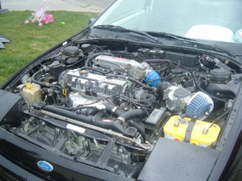 1989 Ford Probe - Engine bay view showing V6 engine, intake, and battery.