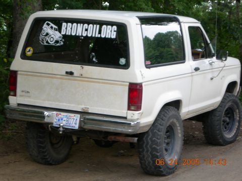 1984 Ford Bronco II - A white 1984 Ford Bronco II is shown with a lifted suspension and off-road tires, viewed from the rear.