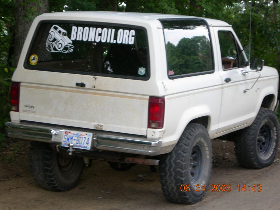 White 1984 Ford Bronco II with lifted suspension and off-road tires, viewed from the rear three-quarter angle