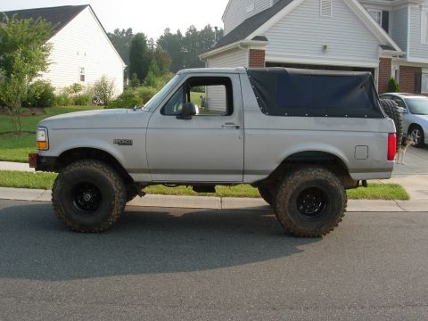 1995 Ford Bronco - This silver 1995 Ford Bronco features a soft top and lifted suspension, giving it a appearance.