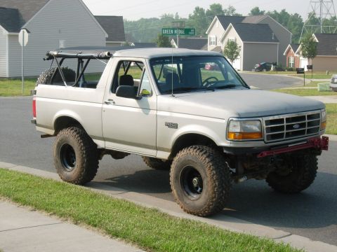 1995 Ford Bronco - This modified Ford Bronco is parked on the side of a residential street with a "Green Hedge" street sign in the background.