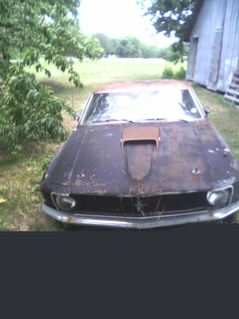 2001 Ford Taurus - This vintage 1969 Ford Mustang shows significant rust and wear, parked in an outdoor setting.
