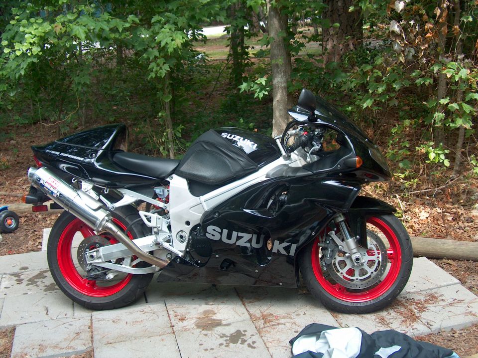 Black 2002 Suzuki TL1000R motorcycle with red rims parked on a patio