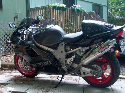 2002 Suzuki TL1000R - A black Suzuki sportbike with red rims and a Yoshimura exhaust is parked on a patio.