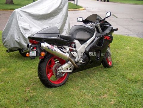 2002 Suzuki TL1000R - A black 2002 Suzuki TL1000R motorcycle is parked on a grassy area next to a covered vehicle.
